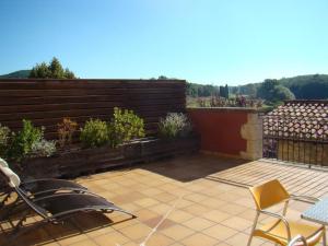 eine Terrasse mit zwei Stühlen und einem Zaun mit Pflanzen in der Unterkunft Can Vilafort in Collsuspina