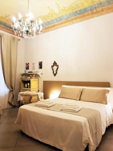 a bedroom with a large bed with a chandelier at Il Sogno Torino Guesthouse in Turin
