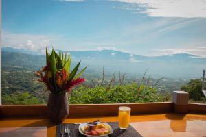 a table with a plate of fruit and a vase of flowers at Barons Resort in Atenas