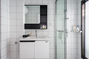 a white bathroom with a sink and a shower at Quzhu Apartment Hotel (Wuhan Hankou Railway Station) in Wuhan