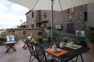 einen Tisch und Stühle mit Sonnenschirm auf einer Terrasse in der Unterkunft Casa Benoi in Rigomagno