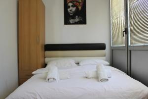 a bedroom with a white bed with towels on it at Apartman Panorama 3 Glavna ulica in Užice