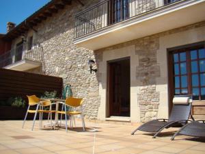 a patio with chairs and a table in front of a building at Can Vilafort in Collsuspina