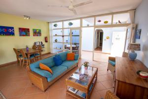 a living room with a blue couch and a table at Windsock Apartment Caribbean Dream in Kralendijk