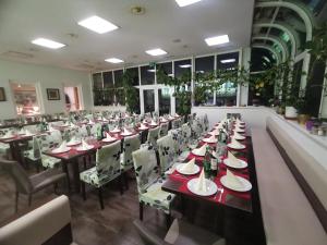 ein Restaurant mit einem langen Tisch mit Tellern und Weinflaschen in der Unterkunft Pension & Restaurant TsingDao in Hörbranz