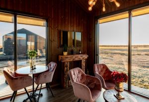 een kamer met een tafel, stoelen en ramen bij Seljalandsfoss Horizons in Hvolsvöllur