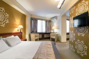 En eller flere senger på et rom på Adria Hotel