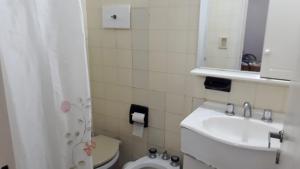 a bathroom with a toilet and a sink and a mirror at Departamento a media cuadra del mar Edificio"Mont Blanc" in Villa Gesell +13 photos