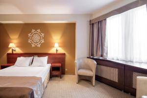 a hotel room with a bed and a desk and a window at Adria Hotel in Kyiv