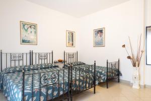 two twin beds in a room with white walls at Villa Alpi in Lignano Sabbiadoro