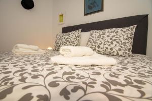 1 dormitorio con 1 cama grande con sábanas y almohadas blancas en Izvor en Ilok
