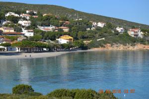 a view of a beach with houses on a hill at Appartamenti al mare in SantʼAntìoco