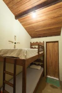 1 dormitorio con 2 literas y techo de madera en Casa Aconchego do Sol 5 minutos do centro, en São Gonçalo do Rio das Pedras