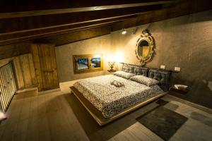 1 dormitorio con cama y espejo en la pared en TENUTA I TUFARI, en Tívoli