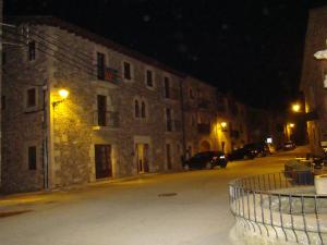 Can Vilafort في Collsuspina: مبنى فيه سيارات تقف في شارع في الليل
