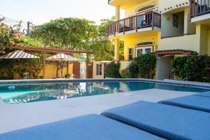 
a swimming pool with a balcony overlooking a beach at Caye Reef Condos in Caye Caulker
