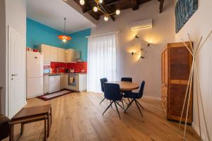 una cucina e una sala da pranzo con tavolo e sedie di Design Apartment Next Sorbillo on Tribunali St By HouseinNaples a Napoli Altre 26 foto