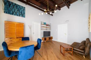 un soggiorno con tavolo in legno e sedie blu di Design Apartment Next Sorbillo on Tribunali St By HouseinNaples a Napoli