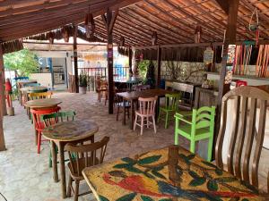 a restaurant with tables and colorful chairs and tables at Pousada Barbara in Pipa