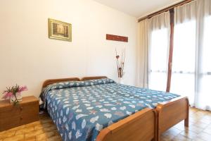 a bedroom with a bed and a large window at villa Sayonara in Lignano Sabbiadoro