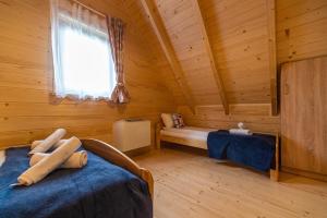 um quarto com duas camas num chalé de madeira em Eko domki MaMastra Szaflary em Szaflary