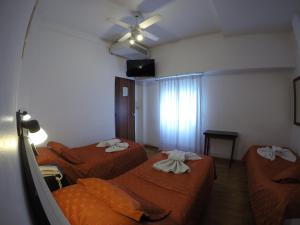 a room with two beds and a ceiling fan at BALOO Hotel in Mar del Plata