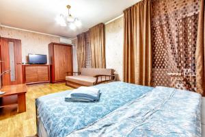 1 dormitorio con 1 cama, 1 silla y TV en 434 Апартаменты на Арбате Самый центр Отлично подходят для командированных и туристов, en Almaty