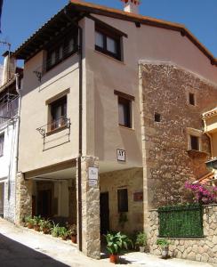 Un grand bâtiment en pierre avec un balcon se trouve dans une rue. dans l'établissement Abuela Pastora, à El Torno