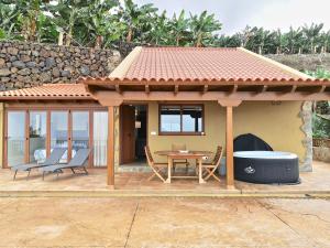 a gazebo with a table and chairs on a patio at Banana Paradise in La Orotava