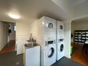 a laundry room with two washes and a sink at Downtown Backpackers Hostel Perth - note - Valid Passport required for check in in Perth