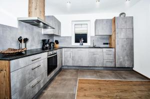 uma cozinha com armários de aço inoxidável e bancadas pretas em Kitz Juwel Top 1 em Hollersbach im Pinzgau