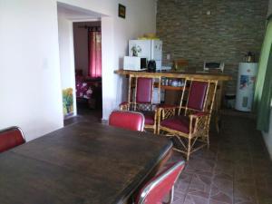 comedor con mesa y sillas y cocina en Cabaña Luna de Pueblo en Salta