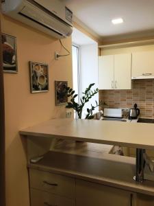 a kitchen with white cabinets and a counter top at уютная студия в Резине in Rezina