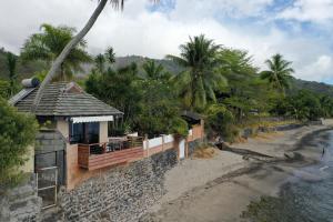 a building on the side of a river with palm trees at AU FARE MOENAU in Paea