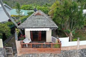 einen Luftblick auf ein kleines Haus mit einer Veranda in der Unterkunft AU FARE MOENAU in Paea