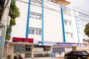 un edificio central del hotel con un coche aparcado delante en Ayenda Hotel Coral, en Santa Marta