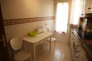 a small kitchen with a table with a laptop on it at Apartamento Vega in Jaca