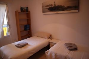 two twin beds in a room with a window at Apartamento Vega in Jaca