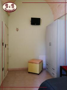 Zimmer mit einem Schrank und einem TV an der Wand in der Unterkunft B&b Desiderato in Latiano