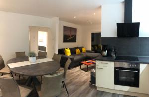 cocina y sala de estar con mesa y sofá en Ferienwohnung Lilie, en Mittelhausen