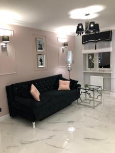 sala de estar con sofá negro y mesa en Apartament Luksusowy z sauną, en Kielce