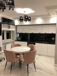 a kitchen with a white table and chairs at Apartament Luksusowy z sauną in Kielce