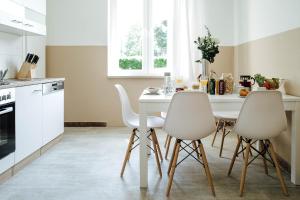 a kitchen with a white table and chairs at Gemütliches Zimmer direkt an der TA (Nr.2) in Hameln