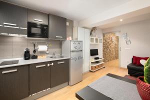 een keuken met roestvrijstalen apparatuur en een woonkamer bij Apartamento Supercentrico in Oviedo