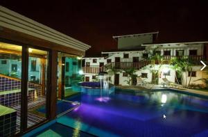 uma piscina em frente a um edifício à noite em Estrada Real Palace Hotel em Brumadinho