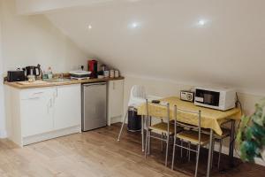 a small kitchen with a table and a microwave at Betty's Loft in Lisburn