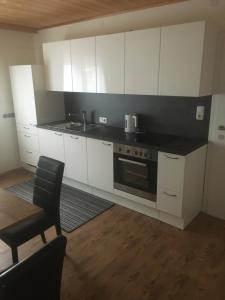 kuchnia z białymi szafkami, zlewem i kuchenką w obiekcie Pension Sunnseitn - Gasthof - Café - Weinkeller w mieście Haslach an der Mühl