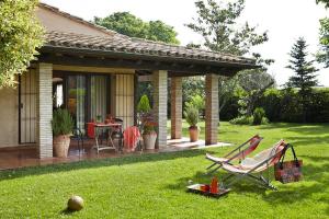 Parlavà的住宿－Mas can Salvi，院子内带椅子和桌子的房子