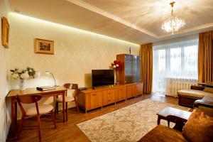a living room with a television and a table and a couch at Apartments at the Central Square in the City Center in Kherson