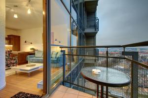 a room with a balcony with a table at Helios 19 Luxury Vilnius Apartment in Vilnius